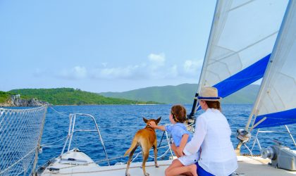 family of mother, child and pet dog sailing on a sunny day