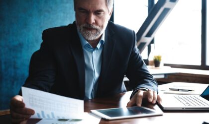 mature male business owner at his desk reading business planning documents