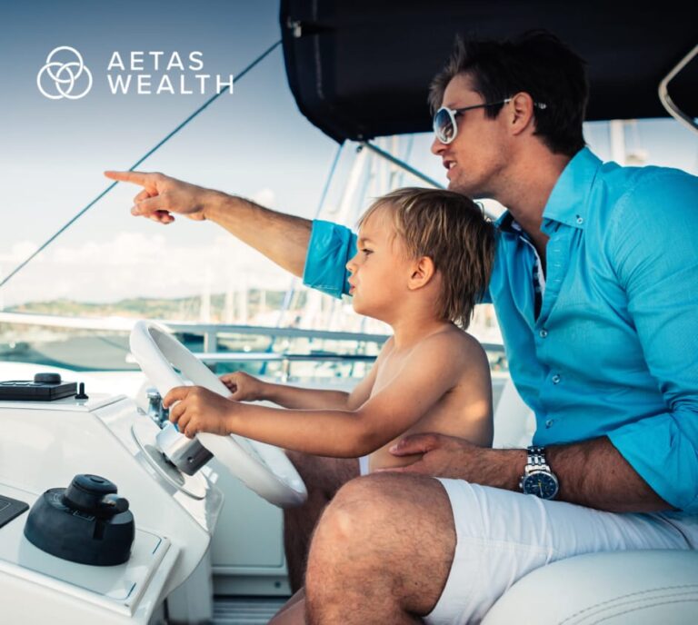 Aetas Wealth image of father with young son steering a yacht, pointing aheaddirection