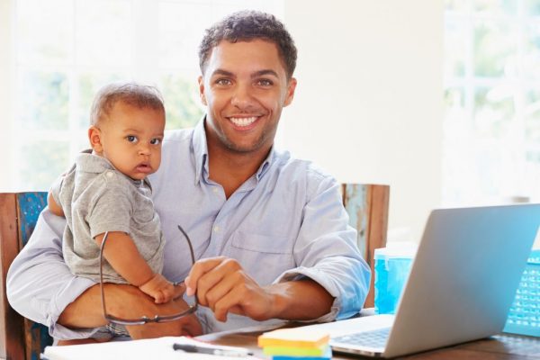 martins-story-lifetime-legacy-builder-aetas-partners father holding his baby son, sitting indoors at home